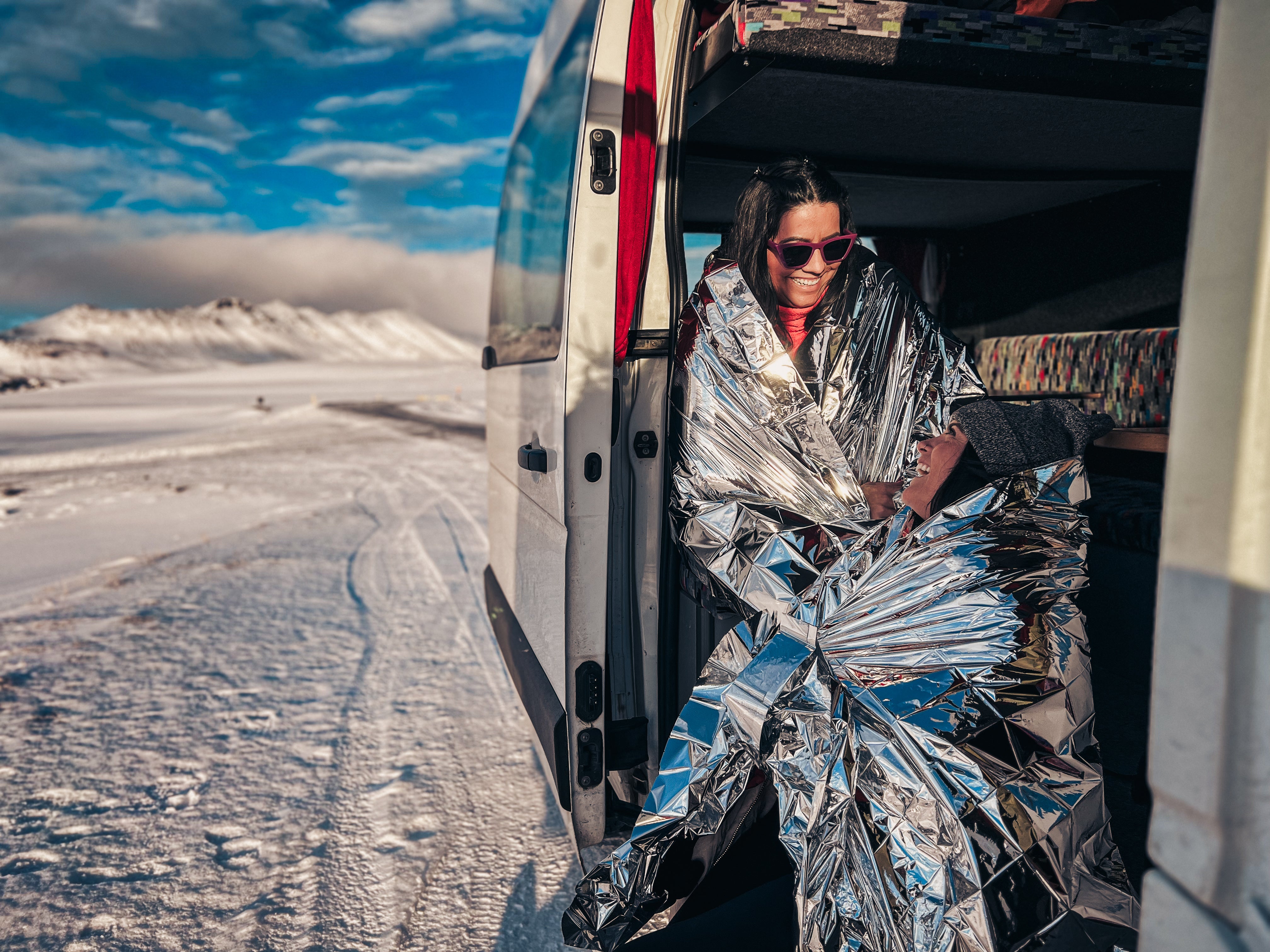 woman using emergency blanket inside the van